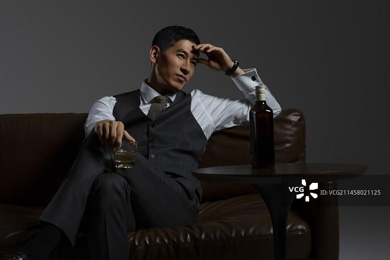 成熟商务男士喝威士忌酒肖像特写图片素材