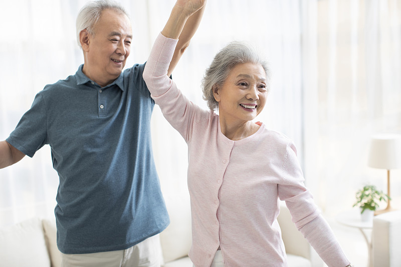 快樂的老年夫婦在客廳跳舞圖片素材