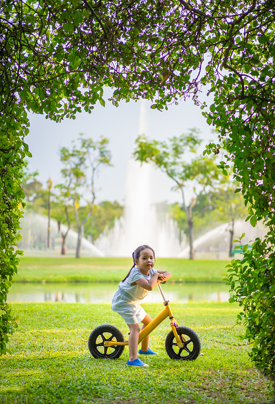 草地上騎自行車的女孩的肖像圖片素材