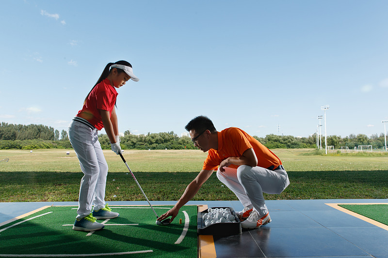 練習場上教練指導女童打高爾夫圖片素材