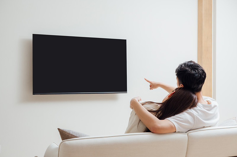 亞洲年輕情侶在家看電視圖片素材
