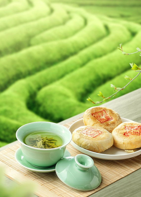 茶園背景的一杯綠茶和蘇式月餅圖片素材