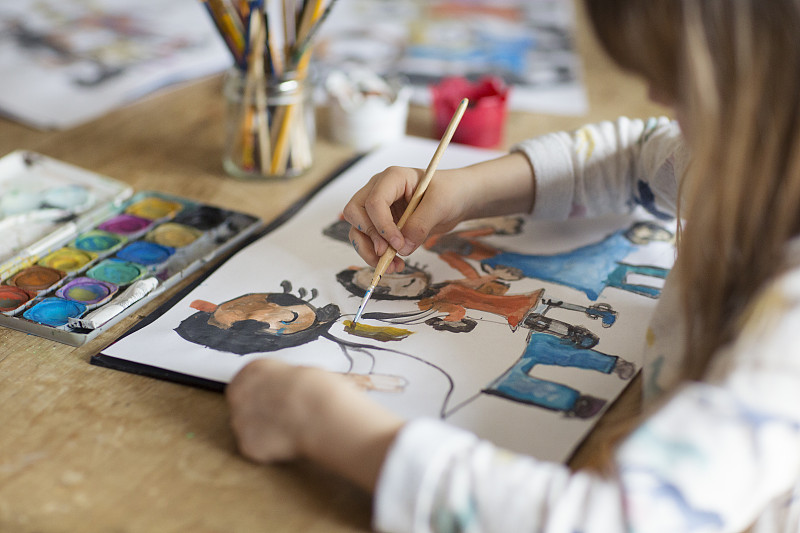 孩子(6-7歲)在紙上畫一個幸福的家庭站在一起圖片素材