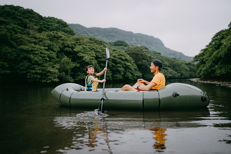 小女孩劃著皮劃艇在紅樹河，Iriomote，日本圖片素材