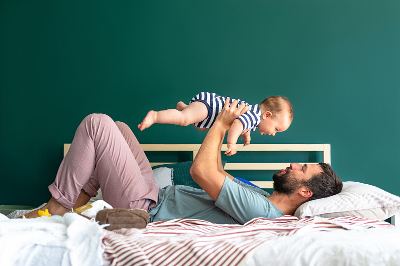 早晨的拥抱:快乐的父亲和儿子分享爱的时刻图片下载
