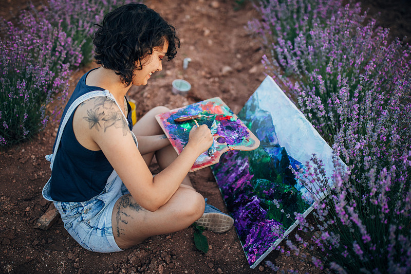 女藝術家在薰衣草地里作畫圖片素材