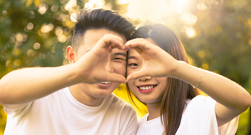 快樂的亞洲男孩和女孩用手指塑造一顆心圖片下載