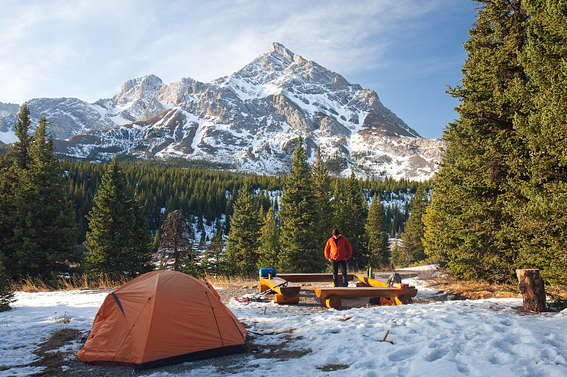 冬季露營在山上，白種人站在火旁圖片素材