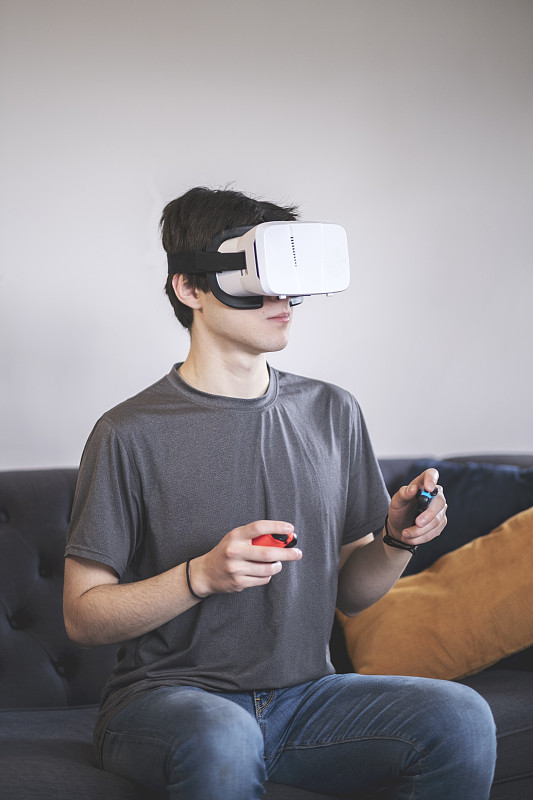 一個年輕人用虛擬現實設備玩游戲圖片素材