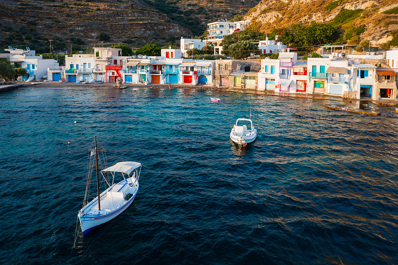 日落時分，希臘米洛斯海邊五顏六色的房子攝影圖片