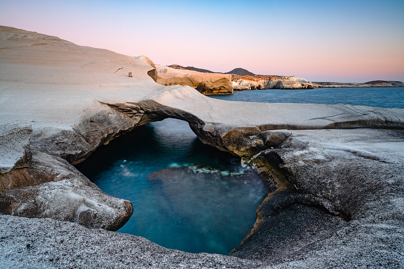 希臘米洛斯的薩拉基尼科，白色的巖石和大海攝影圖片