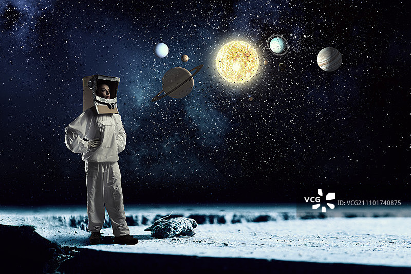 梦想着探索太空。一个头上戴着纸箱的年轻女子想象自己是宇航员图片素材