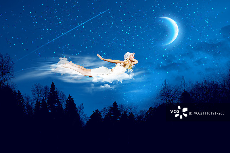 晚上做梦。年轻的金发女孩在夜空中飞翔图片素材