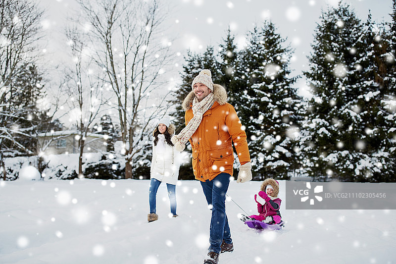为人父母，时尚，季节和人的概念-幸福的家庭与孩子在冬季户外雪橇行走图片素材