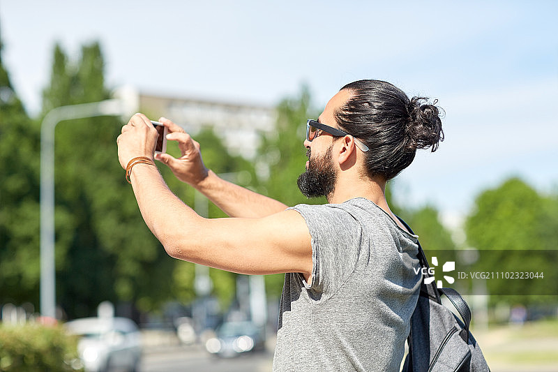 休闲，科技和人的概念-潮人用智能手机在街上拍照或视频图片素材