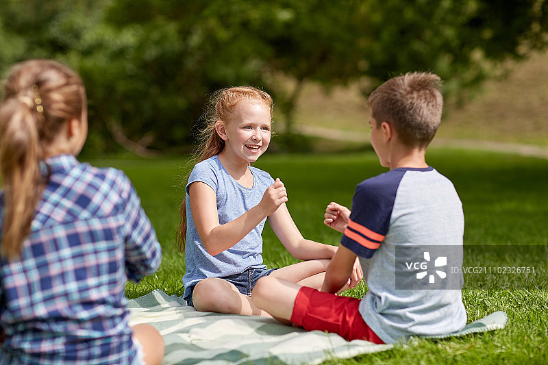 暑假，娱乐，童年，休闲和人的概念-一组快乐的十几岁前的孩子在公园玩石头剪刀布游戏图片素材