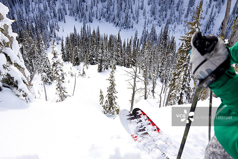 在蒙大拿州的白鱼区附近，一名男性滑雪者向下看一条新的滑雪线图片素材