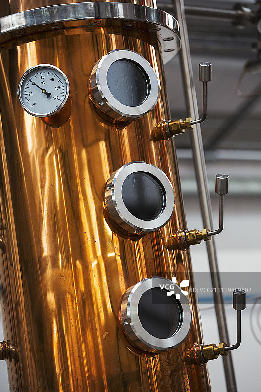 靠近一个仪表和舷窗在侧面的一个铜酿酒厂或发酵室在一个啤酒厂。图片素材