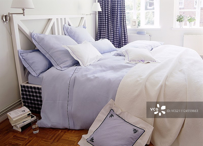 床上有蓝白相间的靠垫、枕头和床单图片素材