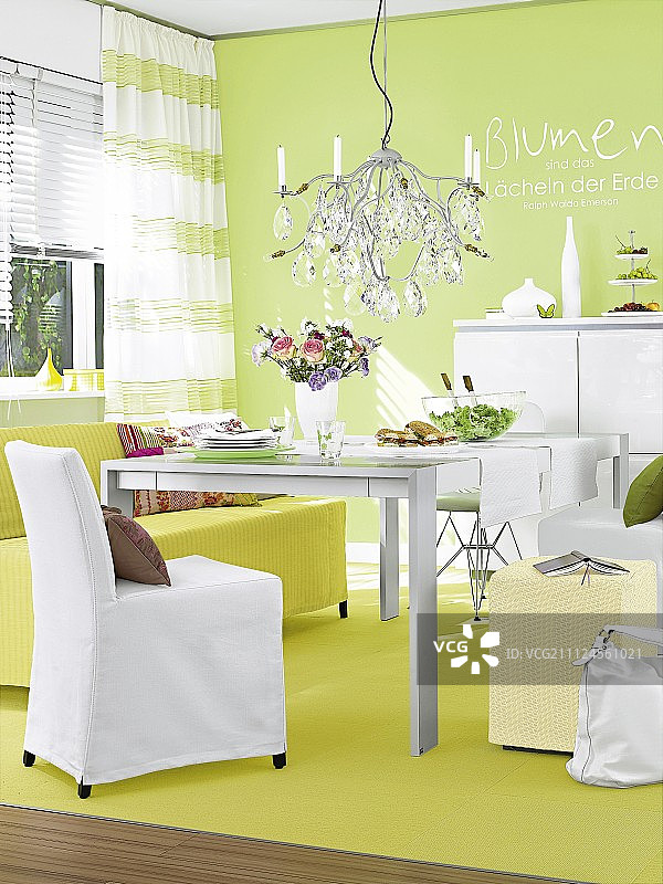 餐厅区域有吊灯，桌子，椅子和黄色的地毯对着绿色的墙壁图片素材