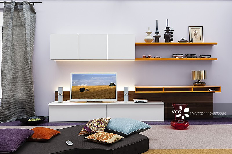 有平板电视的客厅，墙上有靠垫和架子图片素材