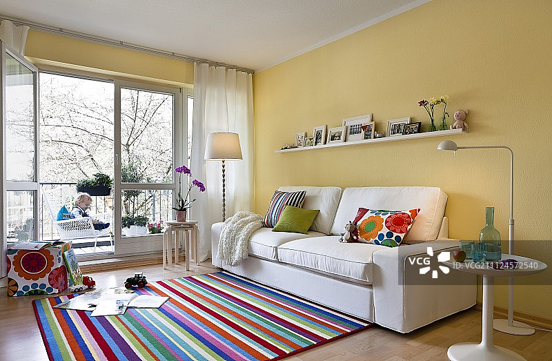 客厅配有彩色条纹地毯、沙发和米色墙壁图片素材