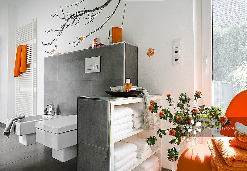 豪华浴室有水池，大窗户和橙色配件图片素材