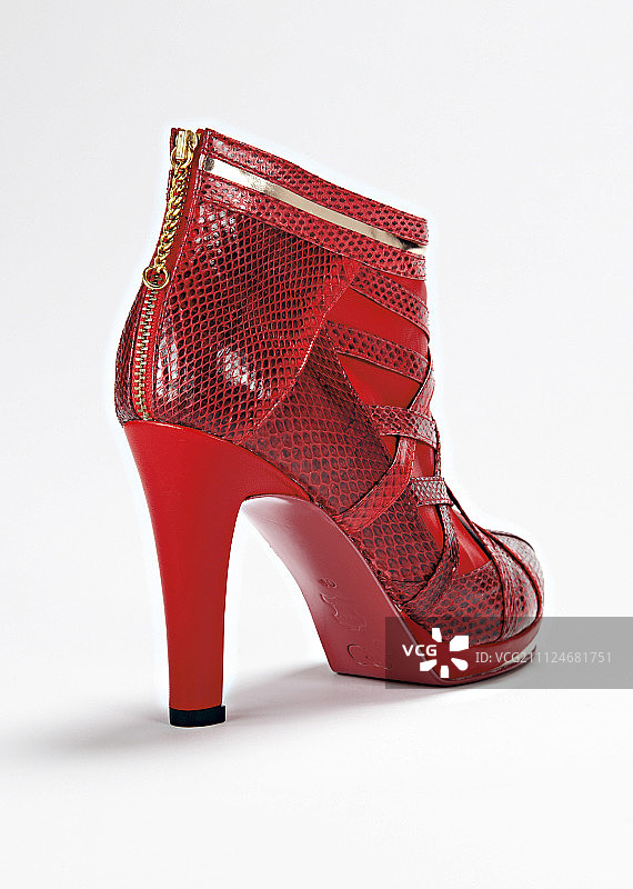 光滑皮革和仿蛇皮踝靴在红色上的白色背景图片素材