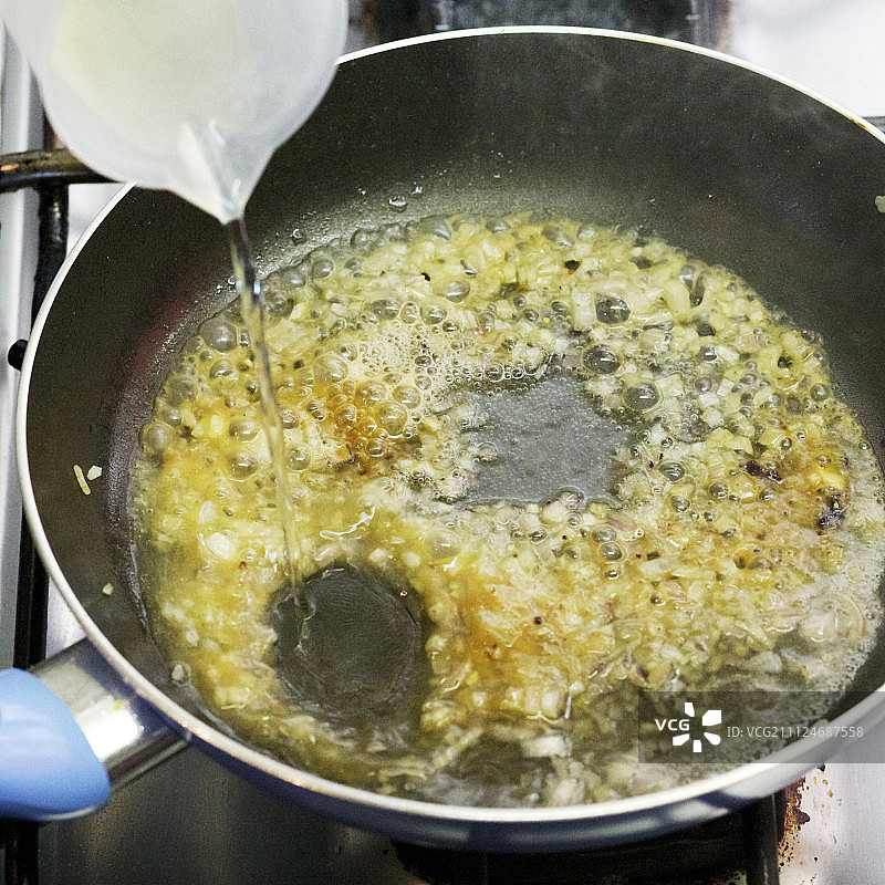 葡萄酒肉汁在平底锅中被去釉的特写图片素材