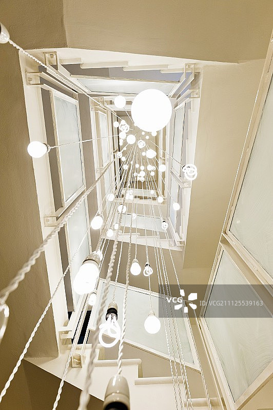 从天花板上可以看到由各种吊灯制成的灯光雕塑图片素材