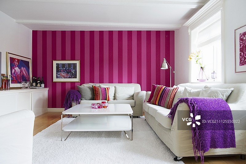 斯堪的纳维亚风格的客厅，白色的家具，红色和粉色的条纹墙纸图片素材