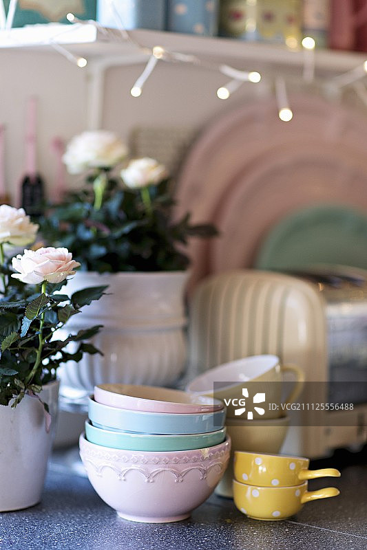 厨房柜台上有碗和杯子，旁边是盆栽玫瑰图片素材