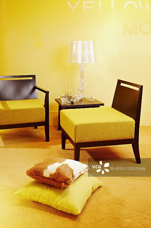 黄色的客厅——木制框架上的厚坐垫和有机玻璃设计的台灯图片素材