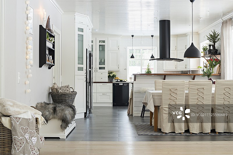 开放式厨房用餐区配有松紧带的椅子，柜台上方有黑色排气罩图片素材