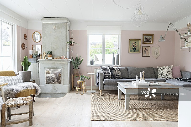 客厅的角落沙发、咖啡桌和壁炉，墙壁是淡粉色图片素材