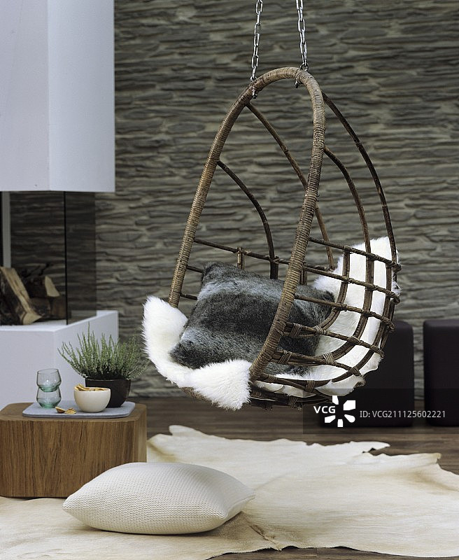 客厅舒适休息区挂椅上的舒适靠垫和羊皮图片素材