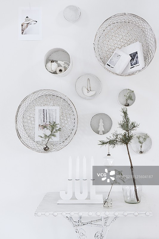 白色的，节日的墙壁装饰上面的烛台和玻璃花瓶在侧桌上图片素材
