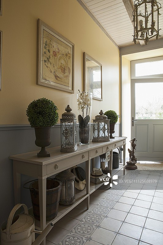 在质朴的走廊里，装饰物桌上挂着灯笼和小灌木图片素材