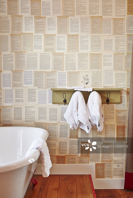 浴缸旁边有毛巾挂钩，墙上有带图案的墙纸图片素材
