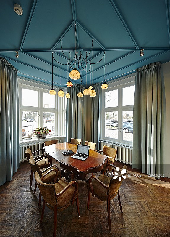 古色古香的桌椅，在蓝色的天花板下有多个吊灯图片素材