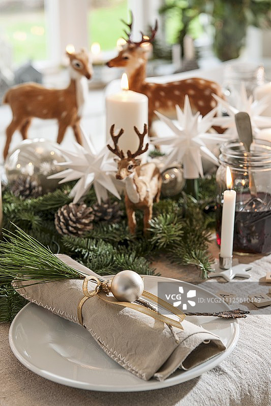 节日餐桌上用松枝和银制小装饰品装饰的亚麻布餐巾图片素材