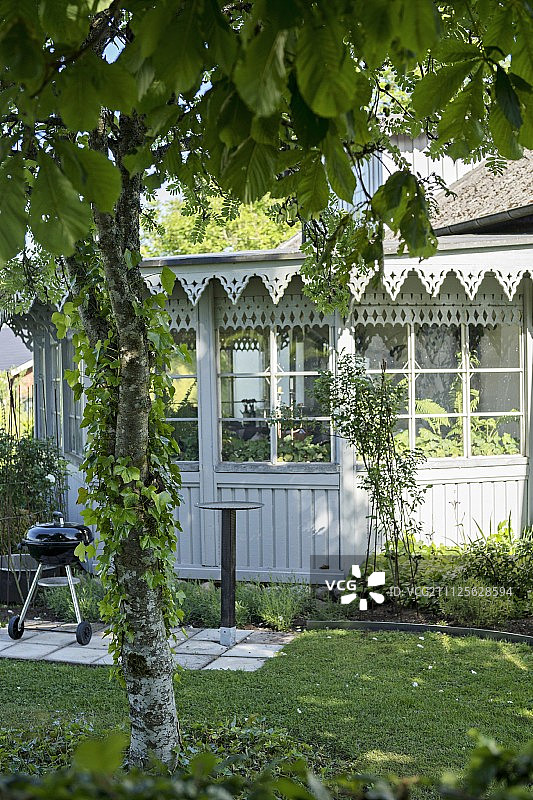 露台在花园外的传统温室与华丽的木屋檐和格子窗图片素材