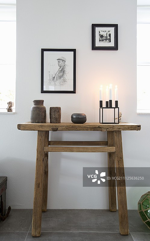 陶瓷艺术品和用再生木材制成的控制台桌上的烛台图片素材