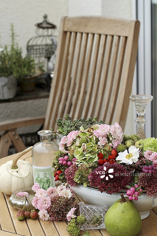 在花园桌子上的盖碗里摆放着秋天的花朵图片素材