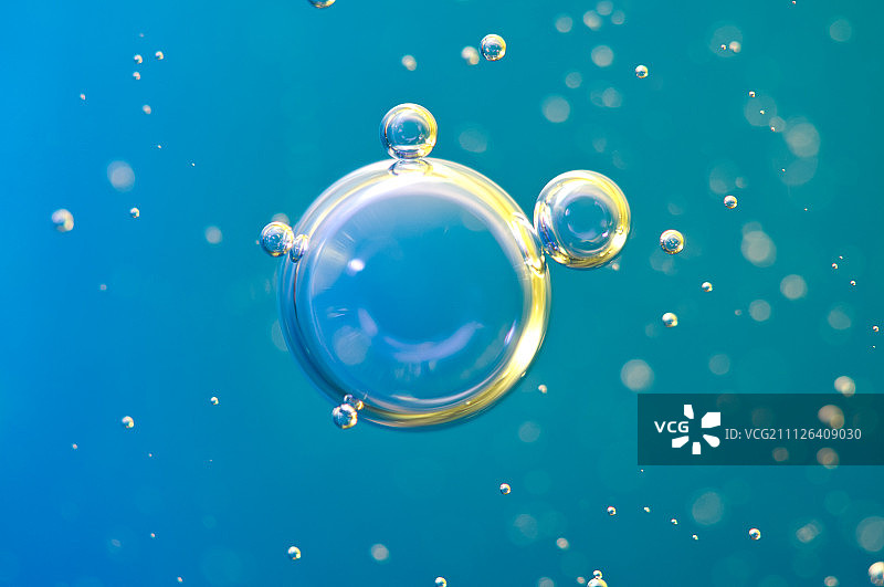 微距氧气气泡在水中的蓝色背景图片素材