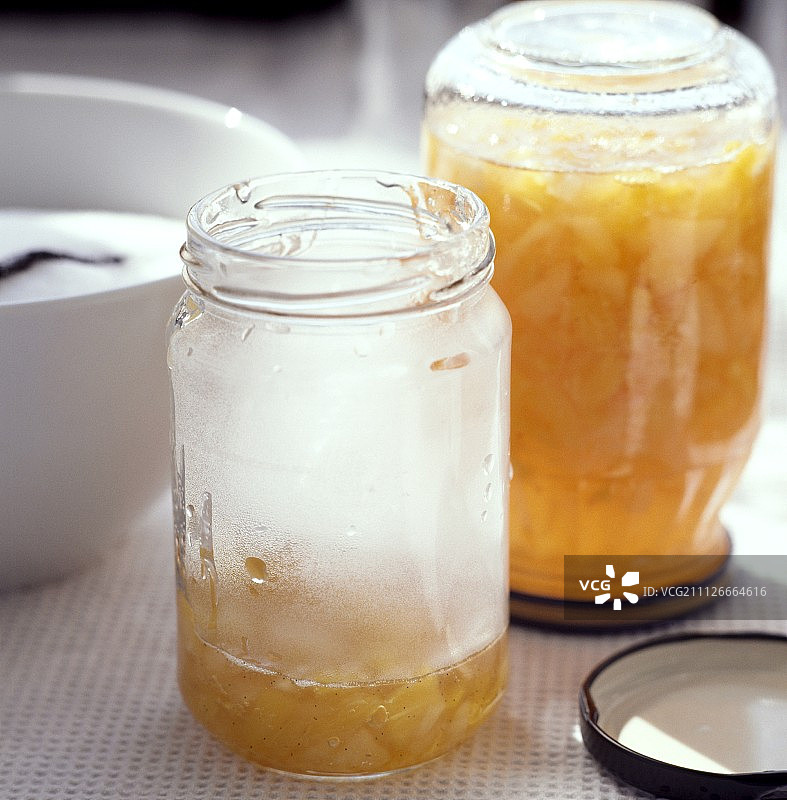 把桃子和菠萝果酱倒进罐子里图片素材