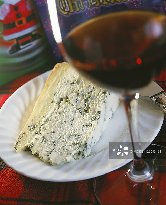盘子里放一块蓝奶酪，还有一杯酒图片素材