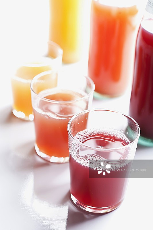 各种各样的果汁在瓶子和玻璃杯图片素材