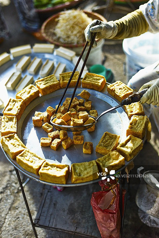 越南海防市，一名妇女在市场上卖炸豆腐图片素材