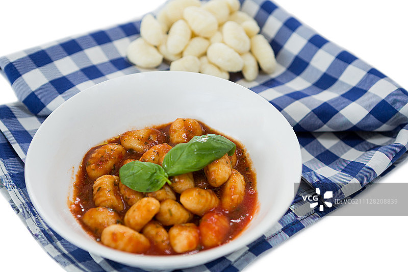 在餐巾上的碗里的意大利汤圆面在白色的背景上的特写图片素材